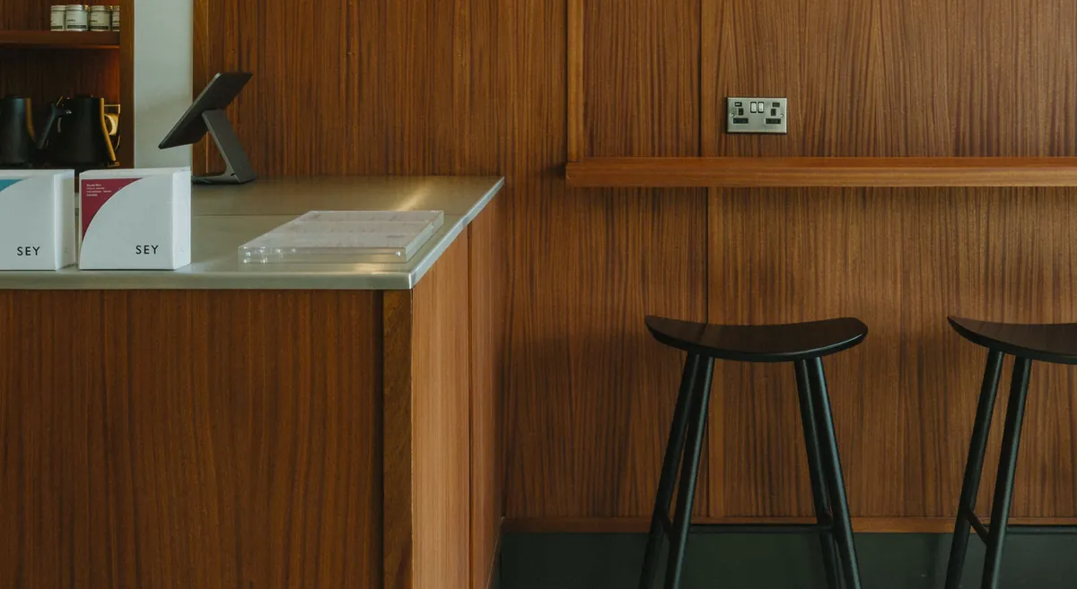 The walnut-panelled counter and black bar stools at Cultura in East Belfast