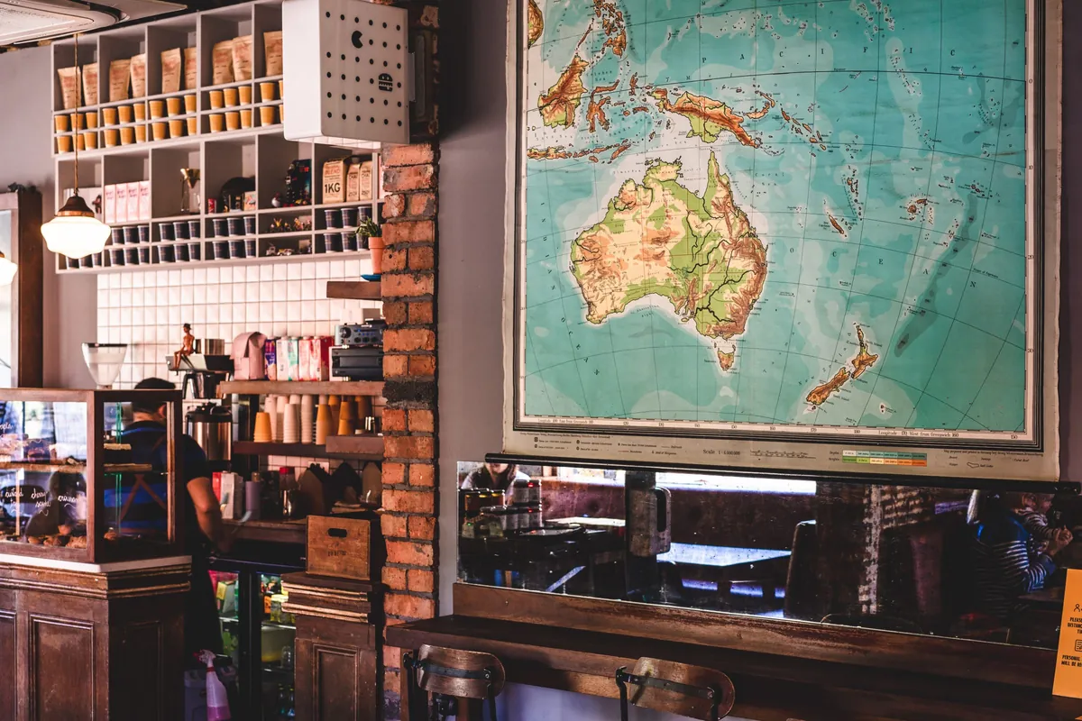 The counter at General Merchants in Belfast, with shelves of jars, a brick pillar and a large vintage map of Australia on the wall