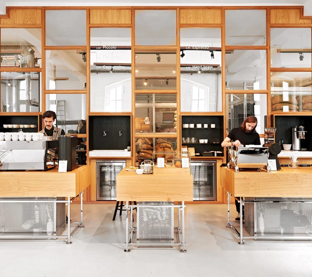 The Bonanza coffee bar, with oak counters, a wood-and-glass partition and two baristas at work