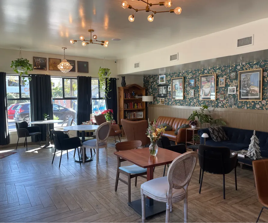 Inside the Texas Coffee Traders café in East Austin, with wooden tables, a dark leather sofa and patterned tiles on the back wall