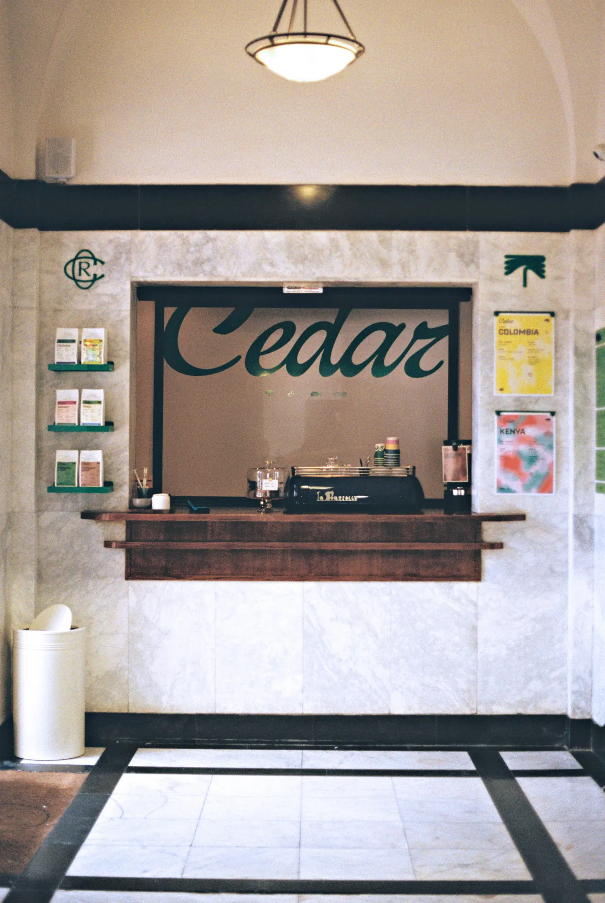 The Cedar Hatch inside Jack Lemkus, a marble-clad hatch with the Cedar name across the window, an espresso machine on a wooden ledge and bags of coffee on small shelves