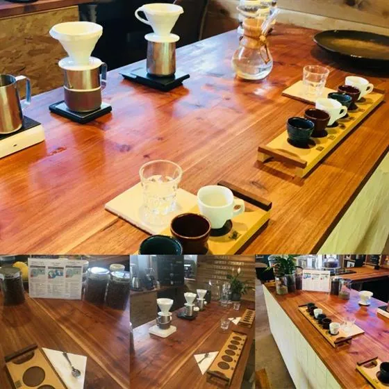 A wooden tasting counter at Quaffee set with two pour-over drippers on stands, a Chemex and small cups on wooden boards