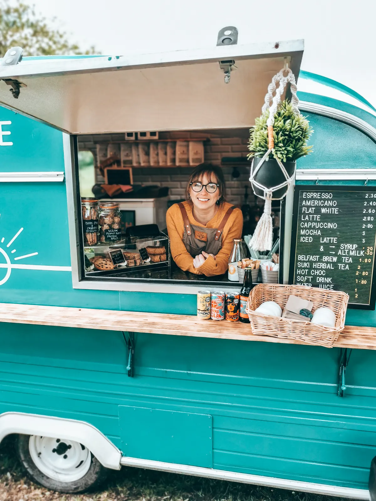 The original Offing coffee cart, a small teal caravan with a barista at the hatch and a chalkboard menu