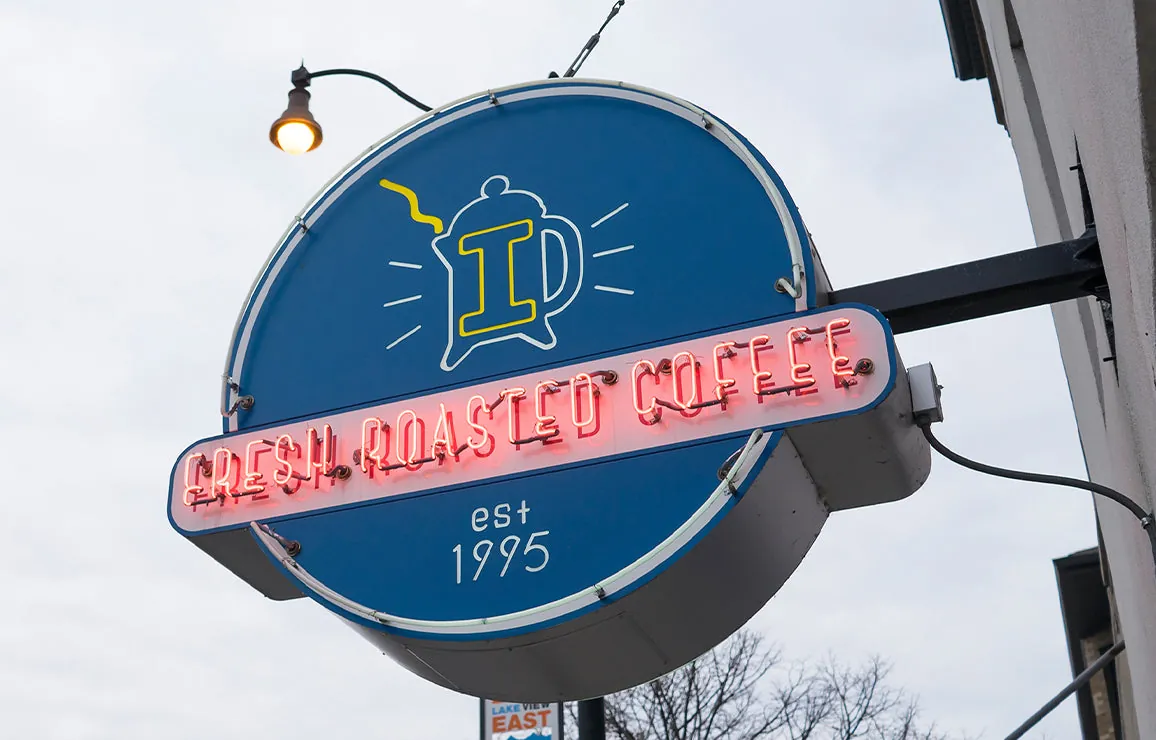 The round blue Intelligentsia sign with red neon reading Fresh Roasted Coffee, est 1995, outside the Broadway Coffeebar in Lakeview, Chicago