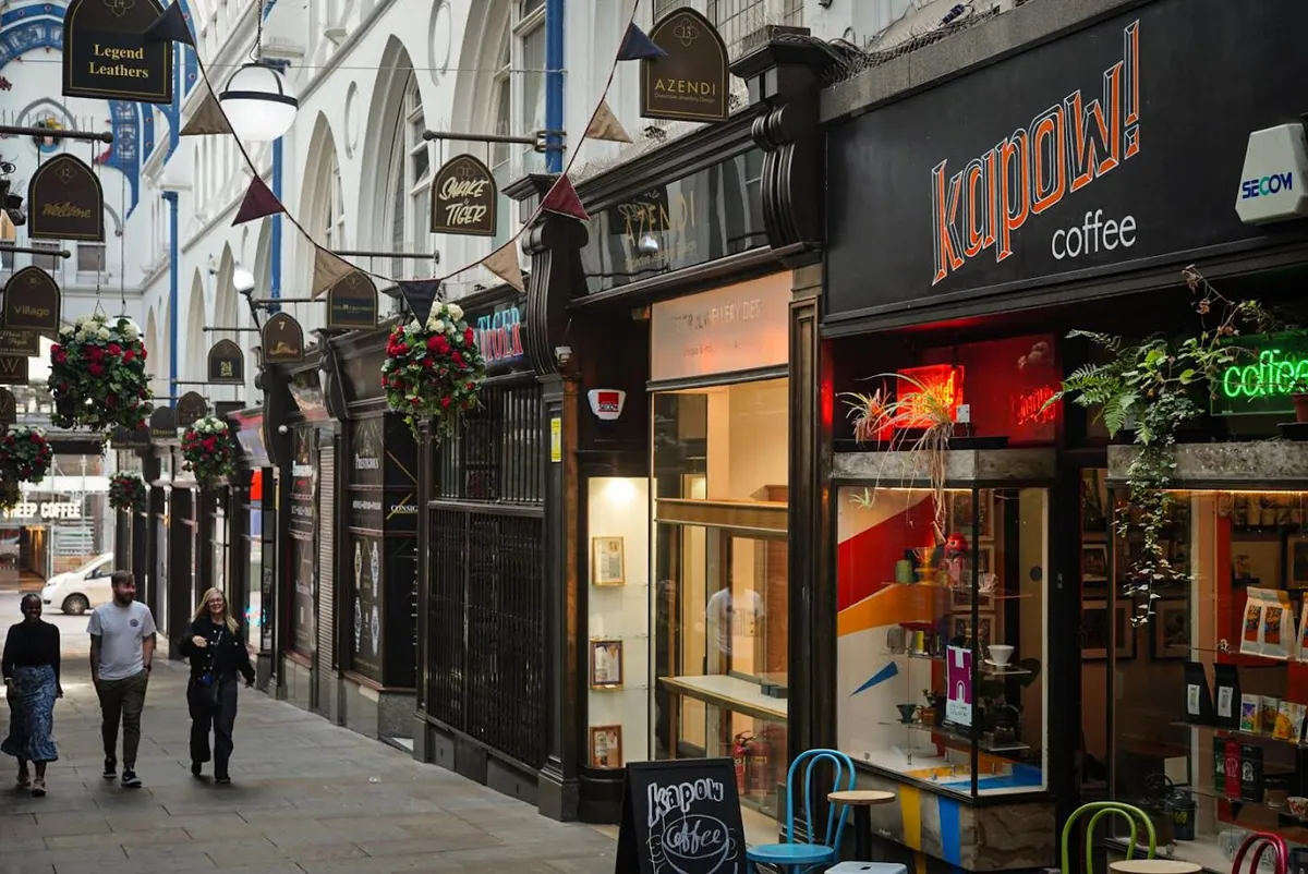 The black Kapow shopfront in Thornton’s Arcade in Leeds, with bunting strung across the glass-roofed arcade above