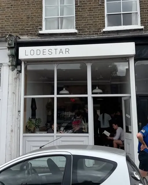 The white shopfront of Lodestar Coffee in Lower Clapton, with the café name above tall windows and customers inside