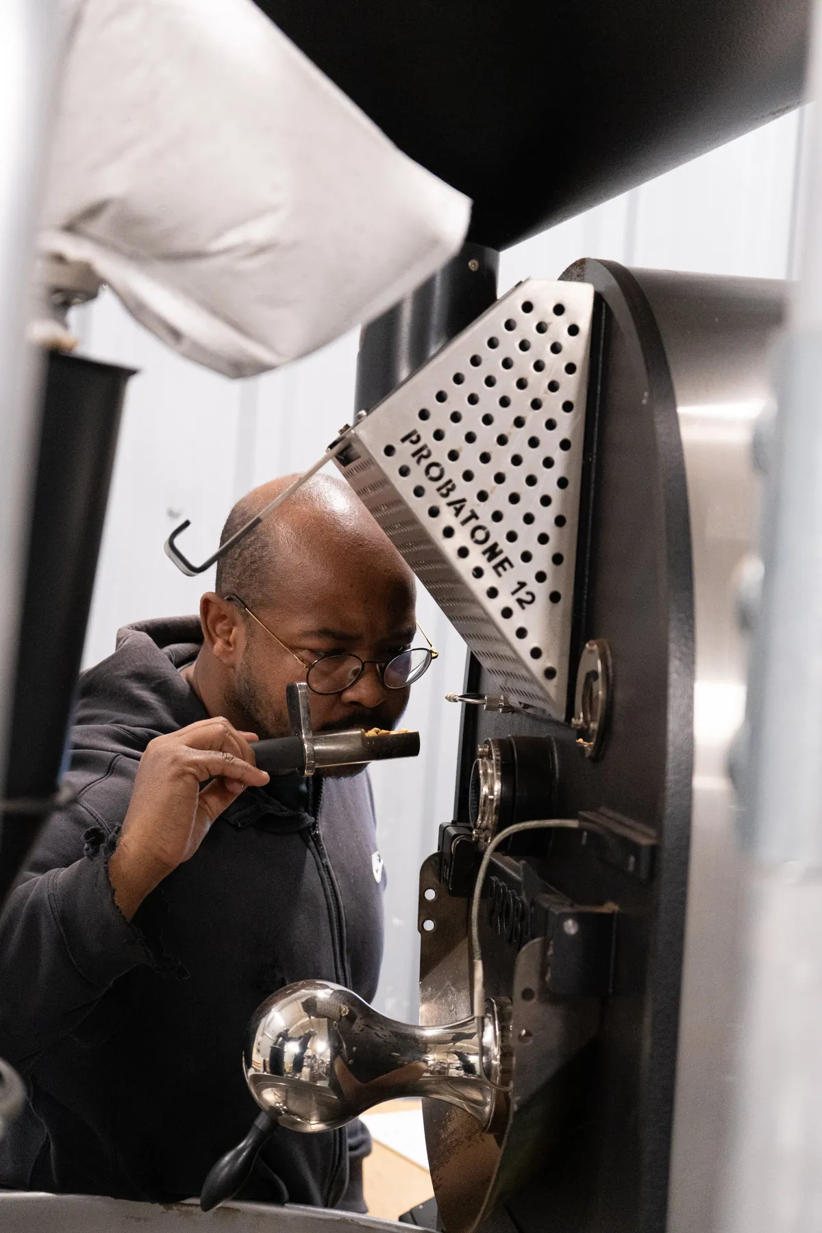 A roaster at Maude checks a sample from the trier of the drum roaster at the roastery in Leeds