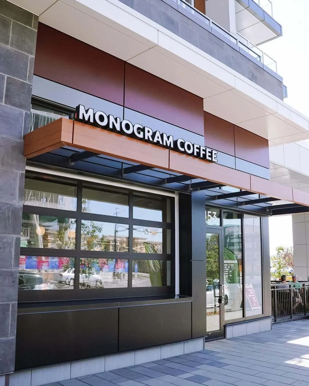 The Monogram Coffee café in the University District, a corner storefront with large framed windows under a wooden canopy and the Monogram Coffee sign