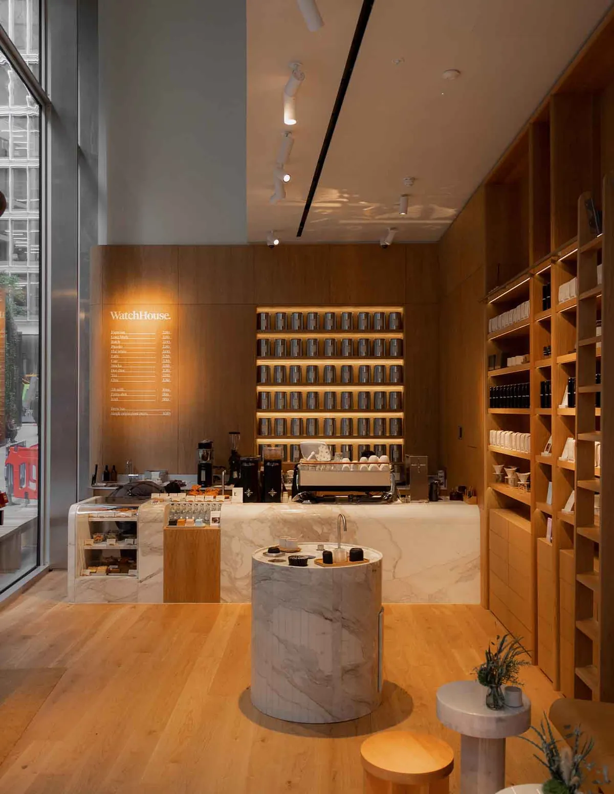 The marble espresso bar, round marble table and oak shelving inside WatchHouse Bishopsgate