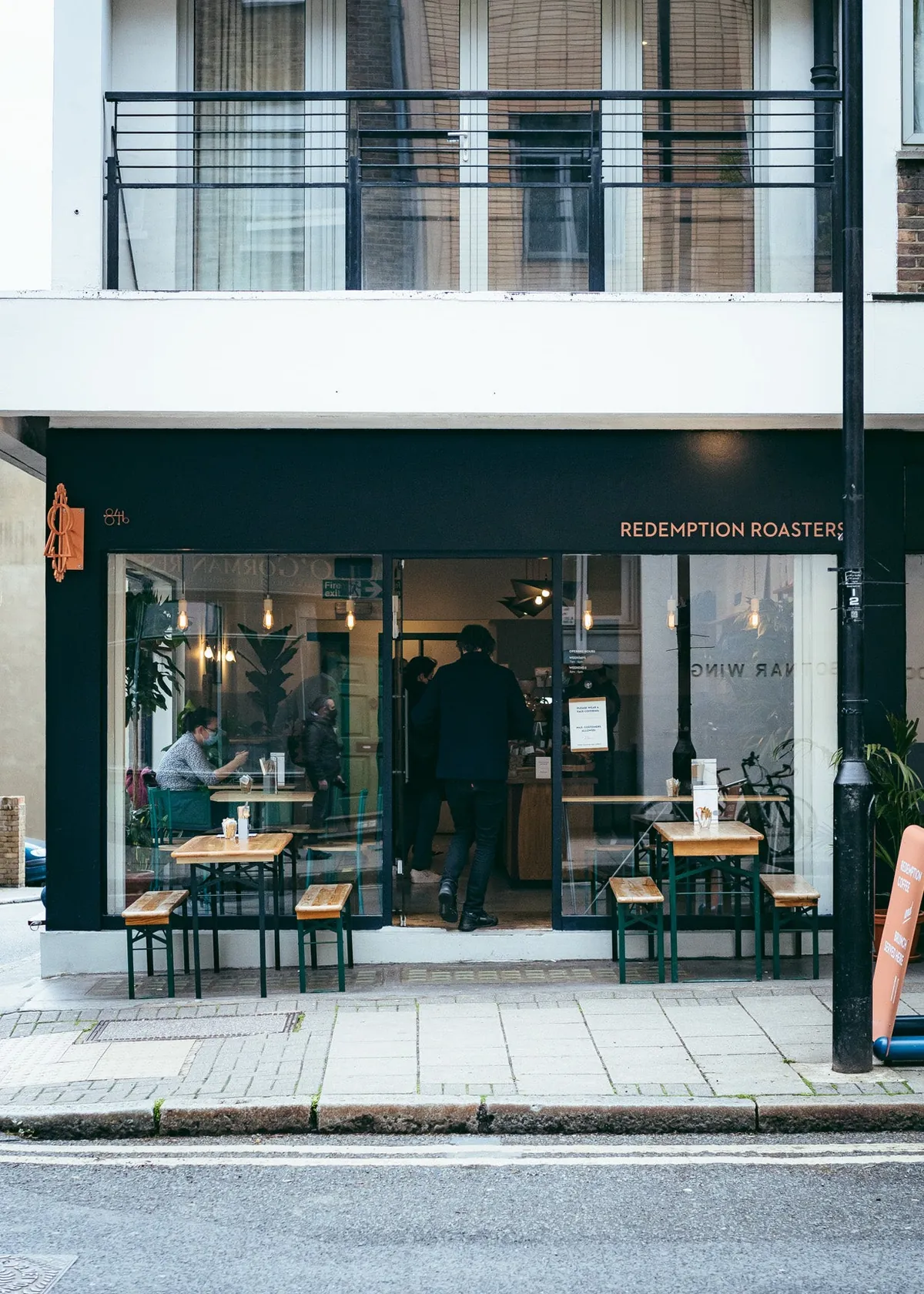 The Redemption Roasters shop in Bloomsbury, with folding tables and benches on the pavement and customers inside