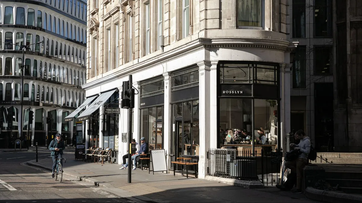 The Rosslyn Coffee shop on a corner in the City of London, with customers on the pavement benches