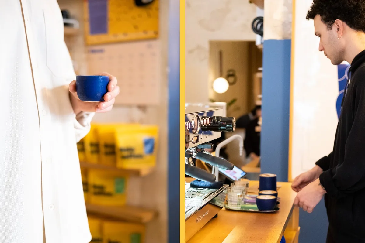 The white counter at Hola Coffee, with a row of grinders, a white espresso machine and a shelf of coloured cups
