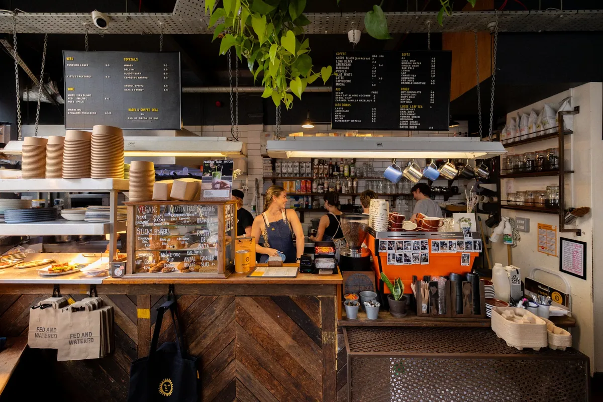 The counter at Federal’s Northern Quarter café, with pastries under glass, letterboard menus and a barista smiling at the till
