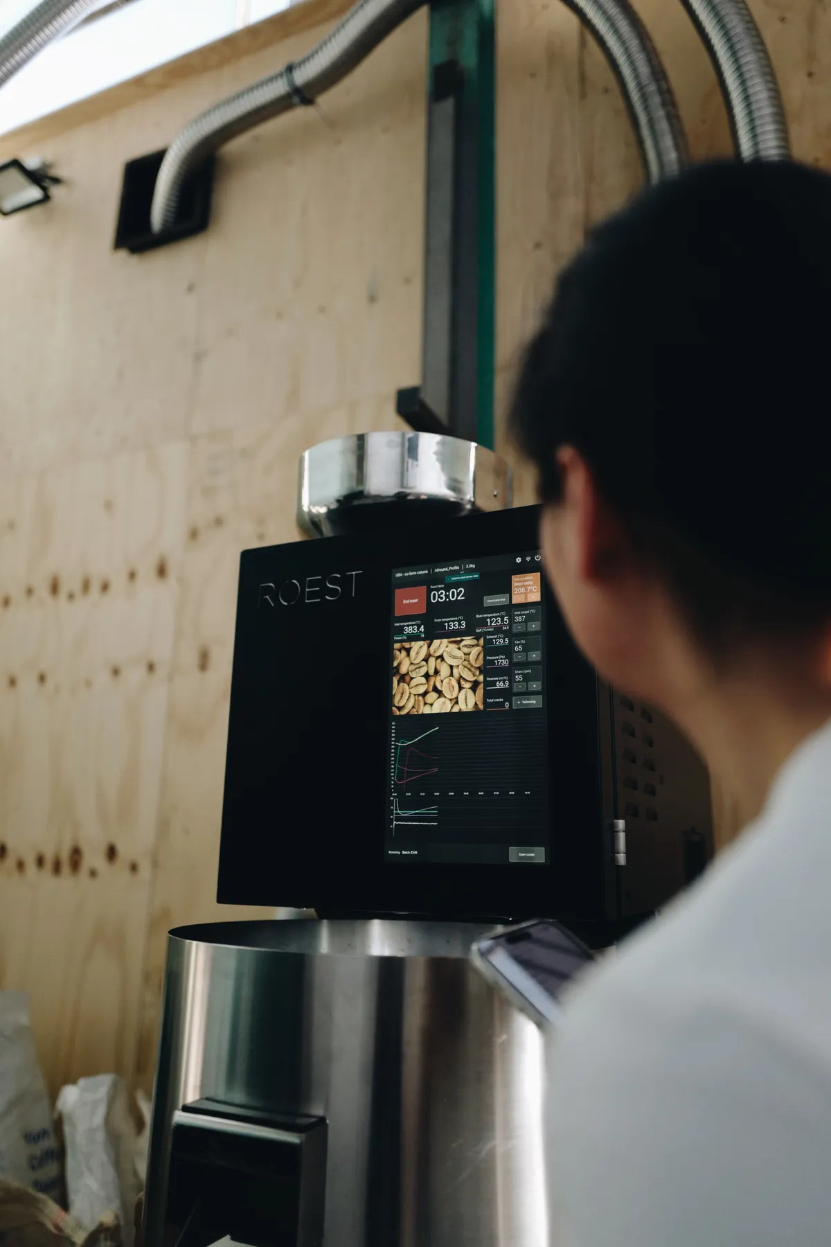A roaster working at a small sample roaster at Mellow Coffee Roasters