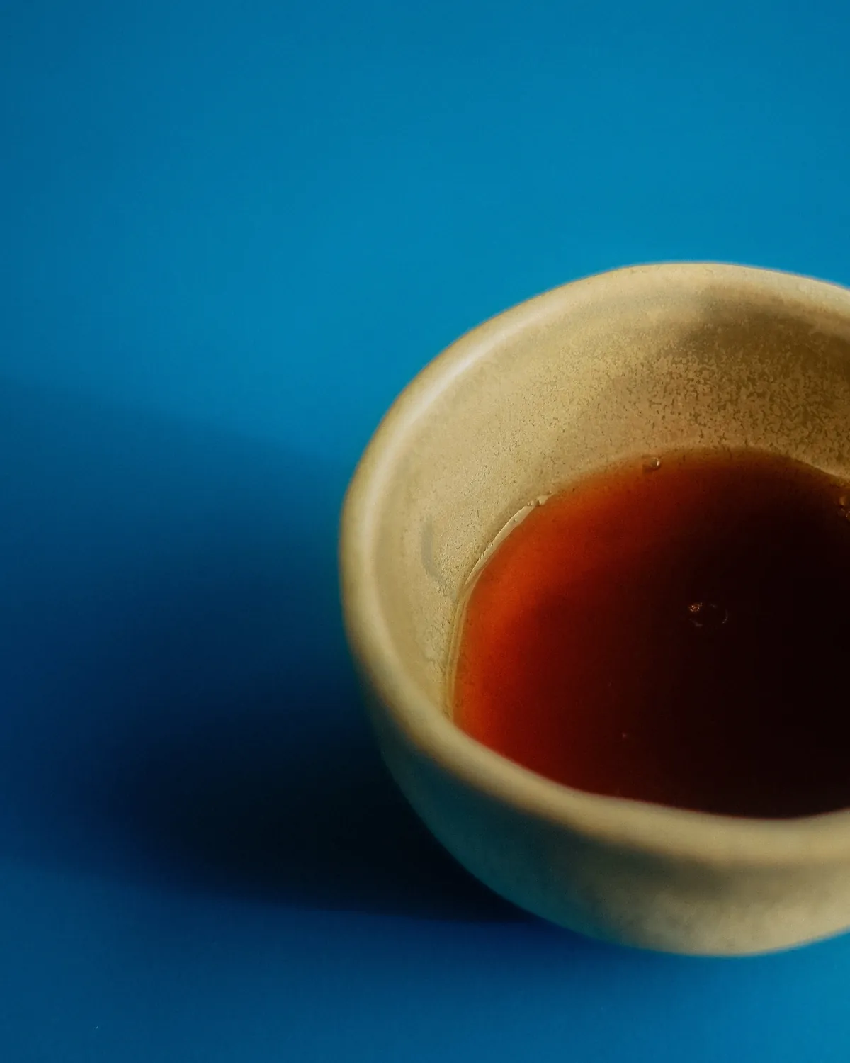 A ceramic cup of black coffee on a blue surface at Saftig