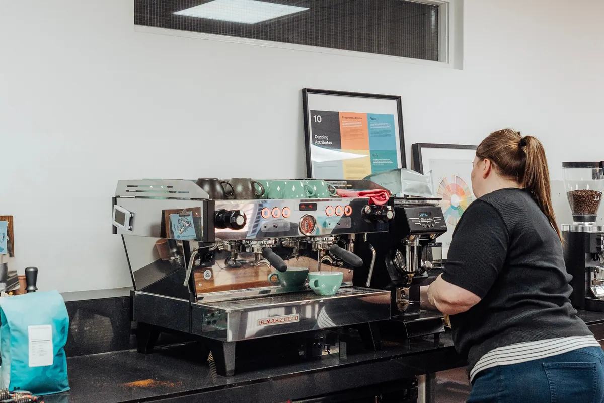 A barista at a La Marzocco espresso machine in the training room at the Bailies Coffee Roasters roastery in Belfast
