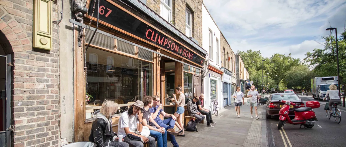 The Climpson & Sons café on Broadway Market, with customers sitting on benches along the shopfront