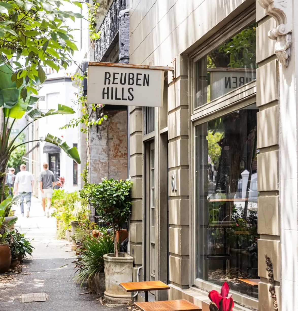 The Reuben Hills sign above the shopfront in Surry Hills, with plants and small tables on the pavement