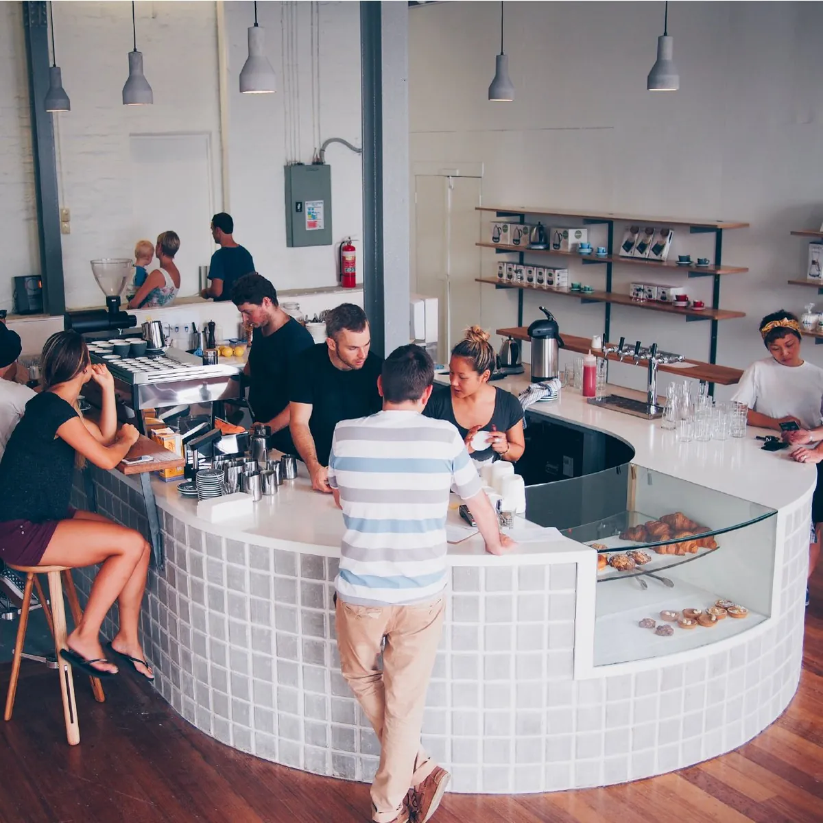 The white-tiled curved counter at Sample’s St Peters Pro Shop, with staff behind it and customers waiting